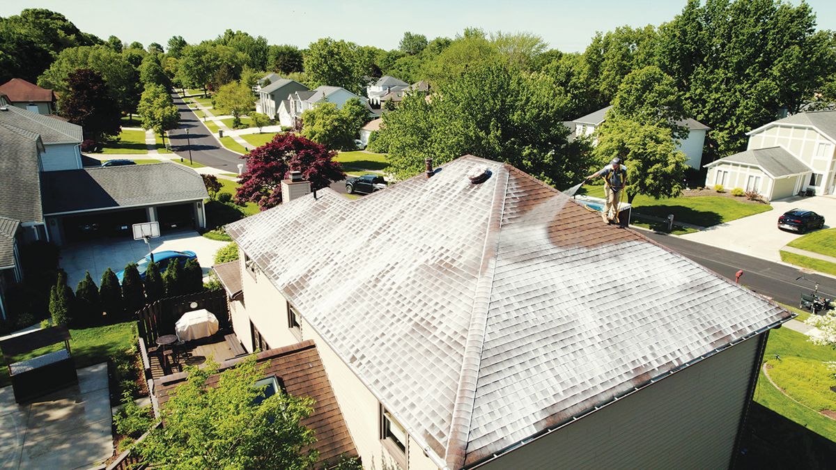 High-angle view of a residential house roof with significant light-colored staining or mineral buildup.
