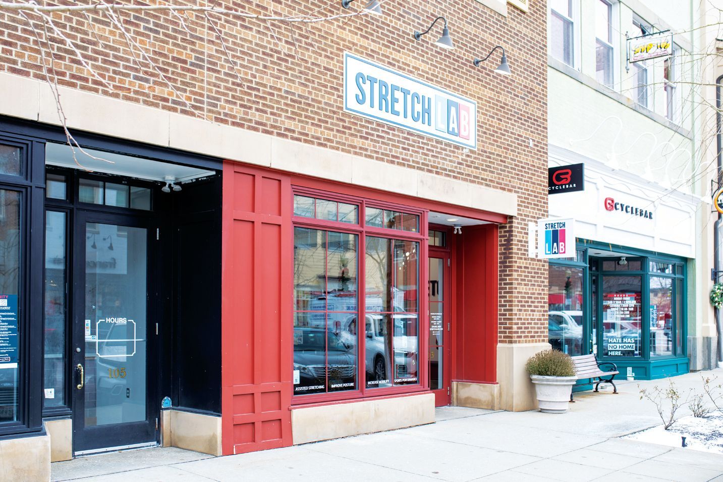 A brick storefront with a red window frame and a sign reading 