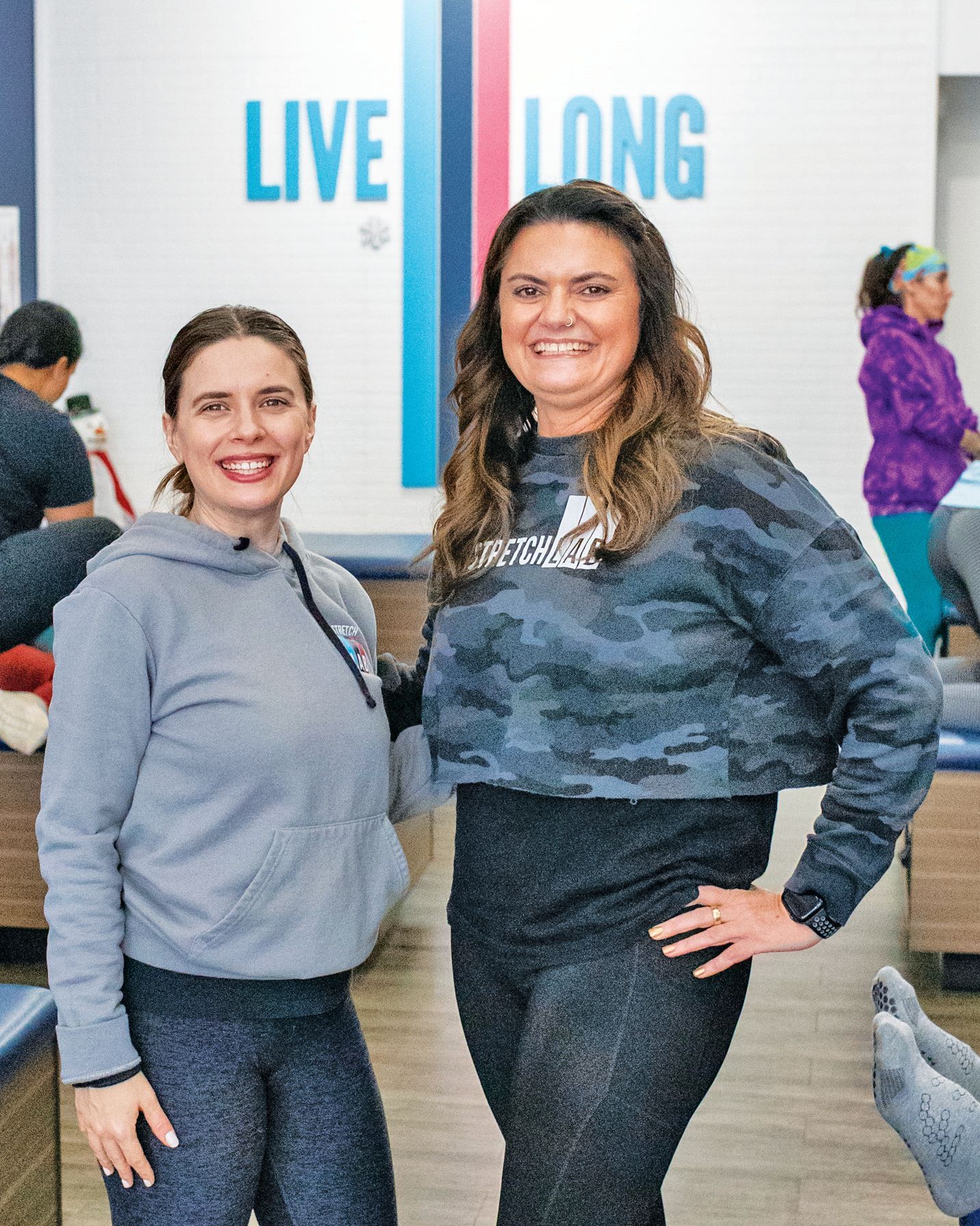 Two people smiling in a gym setting with a 