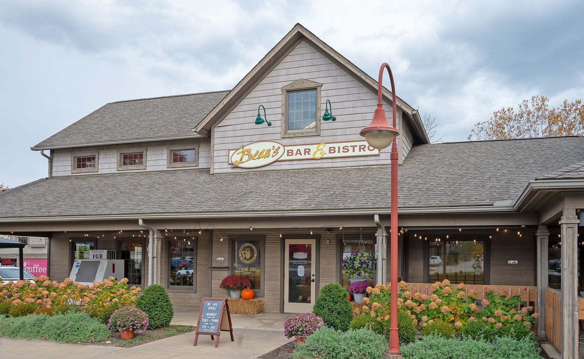 A stone building with a shingled roof, featuring a sign for 