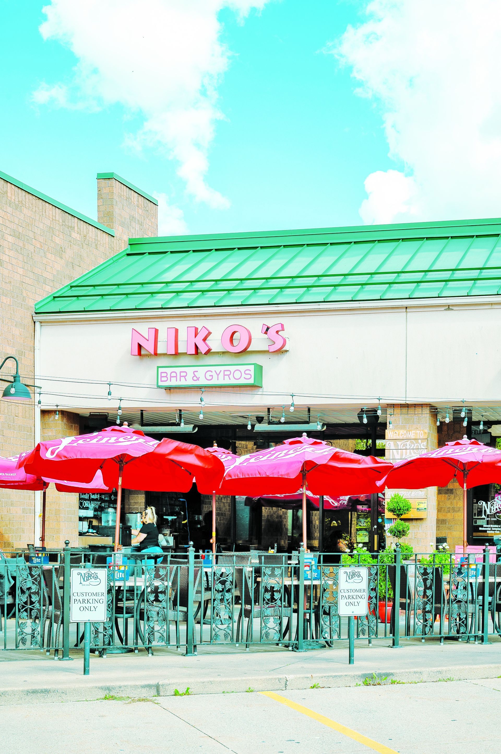 A storefront with a green metal roof and a sign reading 