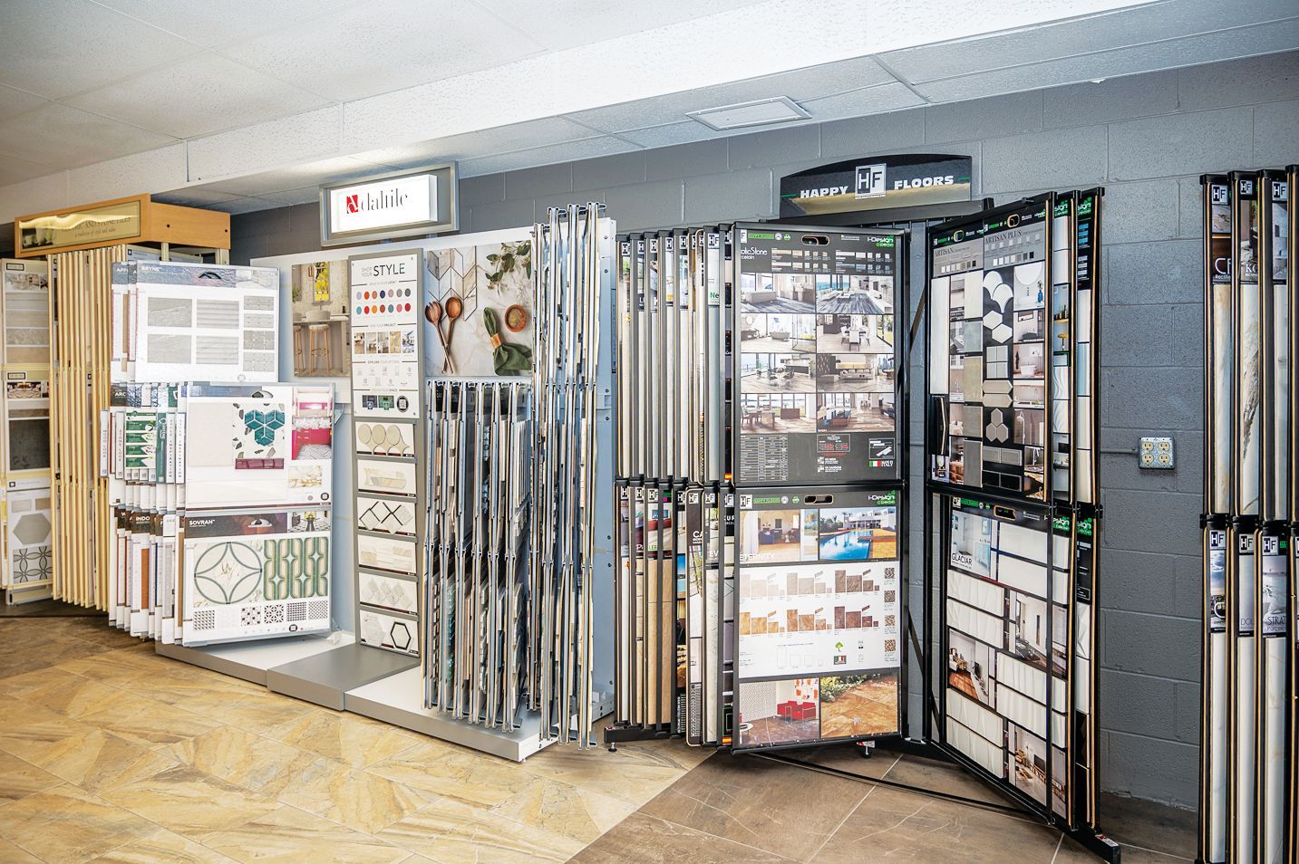 A retail showroom display featuring various home improvement flooring samples, including boards, tiles, and catalogs.