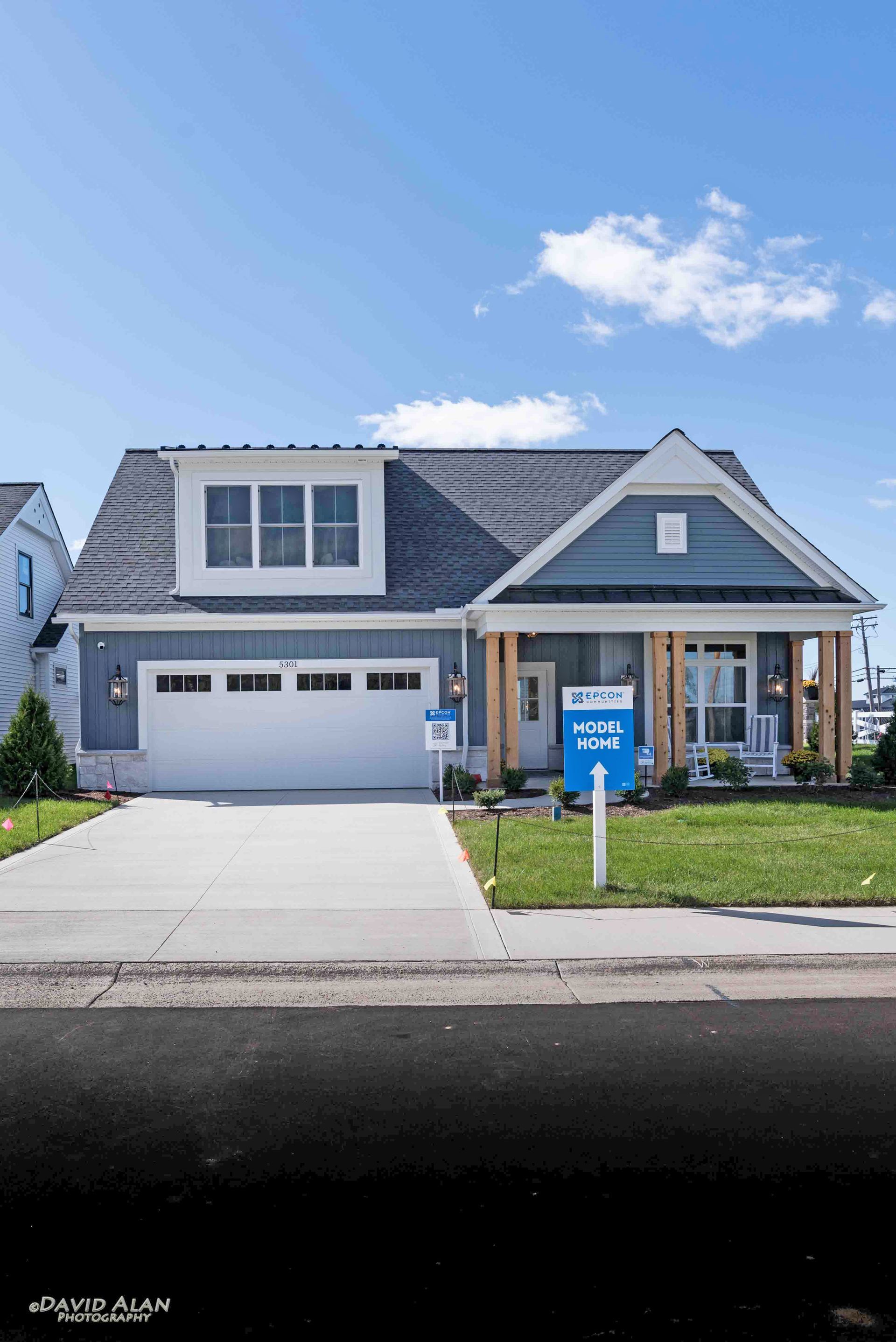 A suburban two-story house with blue siding, a white garage, and a