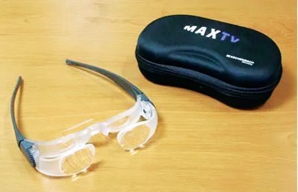 MaxTV magnifying glasses with a black storage case on a light wood surface.