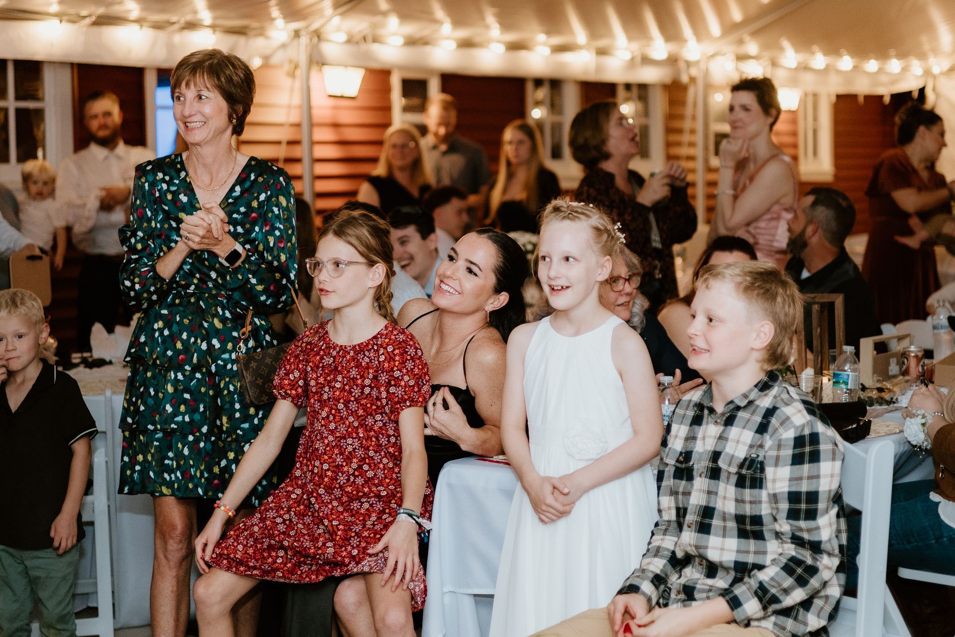 A group of people are sitting in a room at a wedding reception.