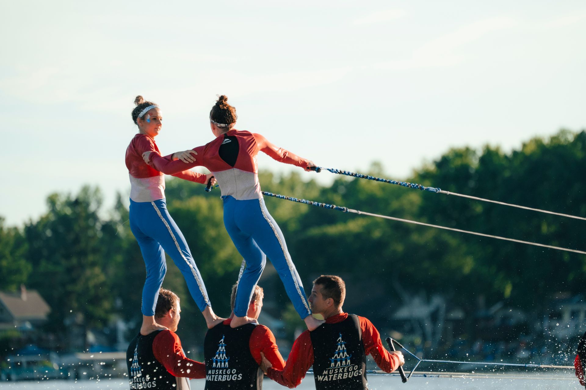 A group of people are standing on top of each other in the water.