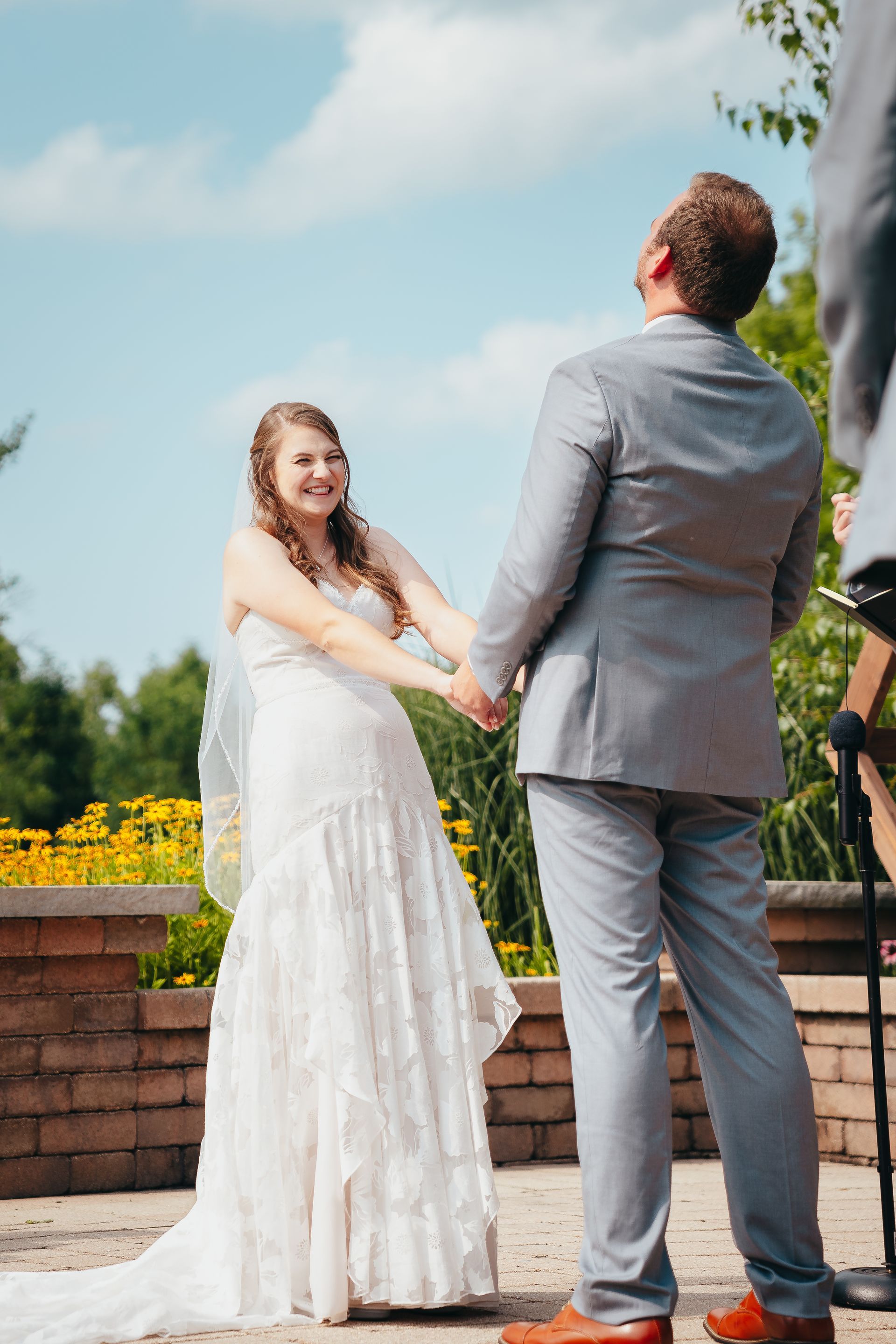 Bride and groom holding hands outdoors during a wedding ceremony