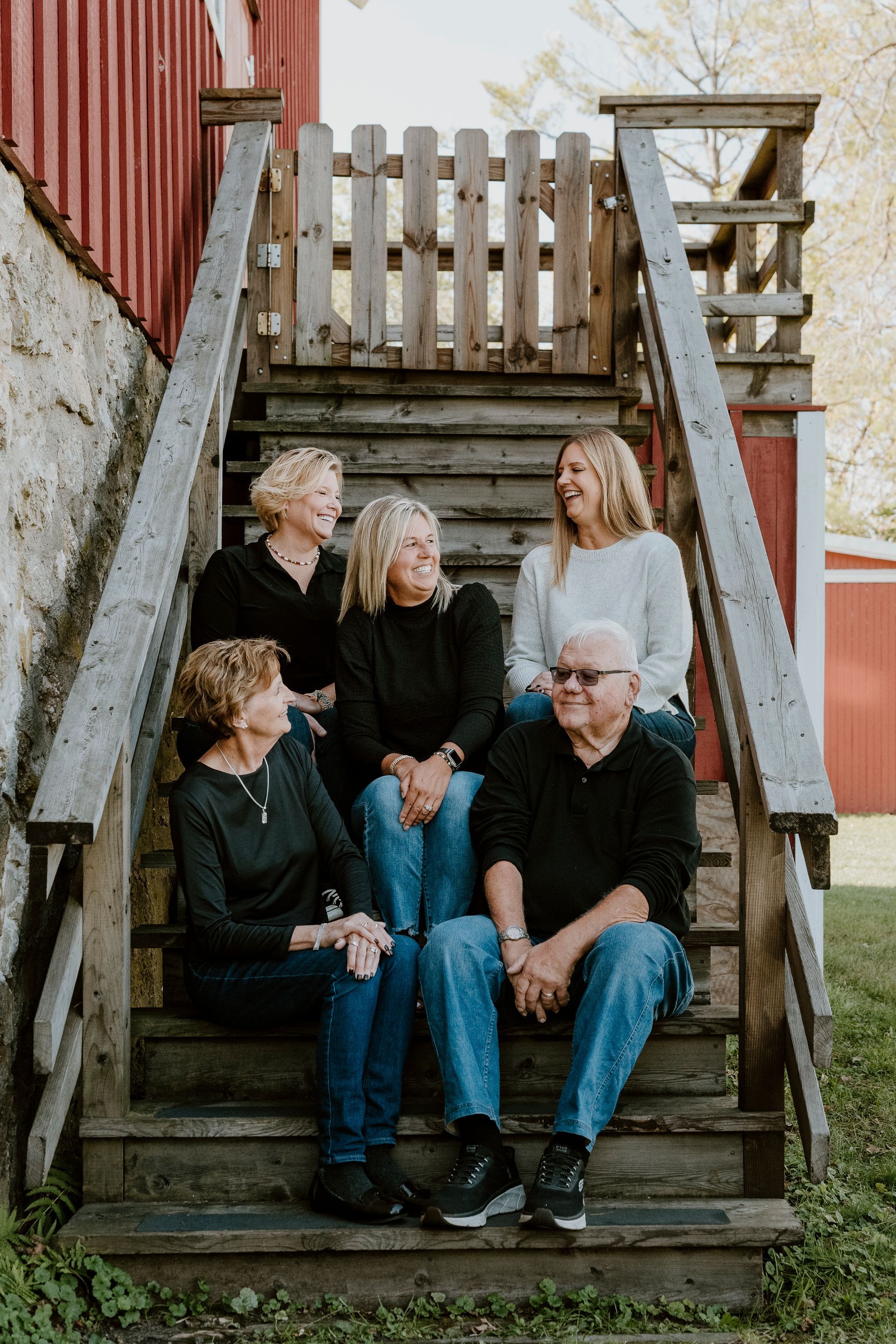A group of people are sitting on a set of wooden stairs.