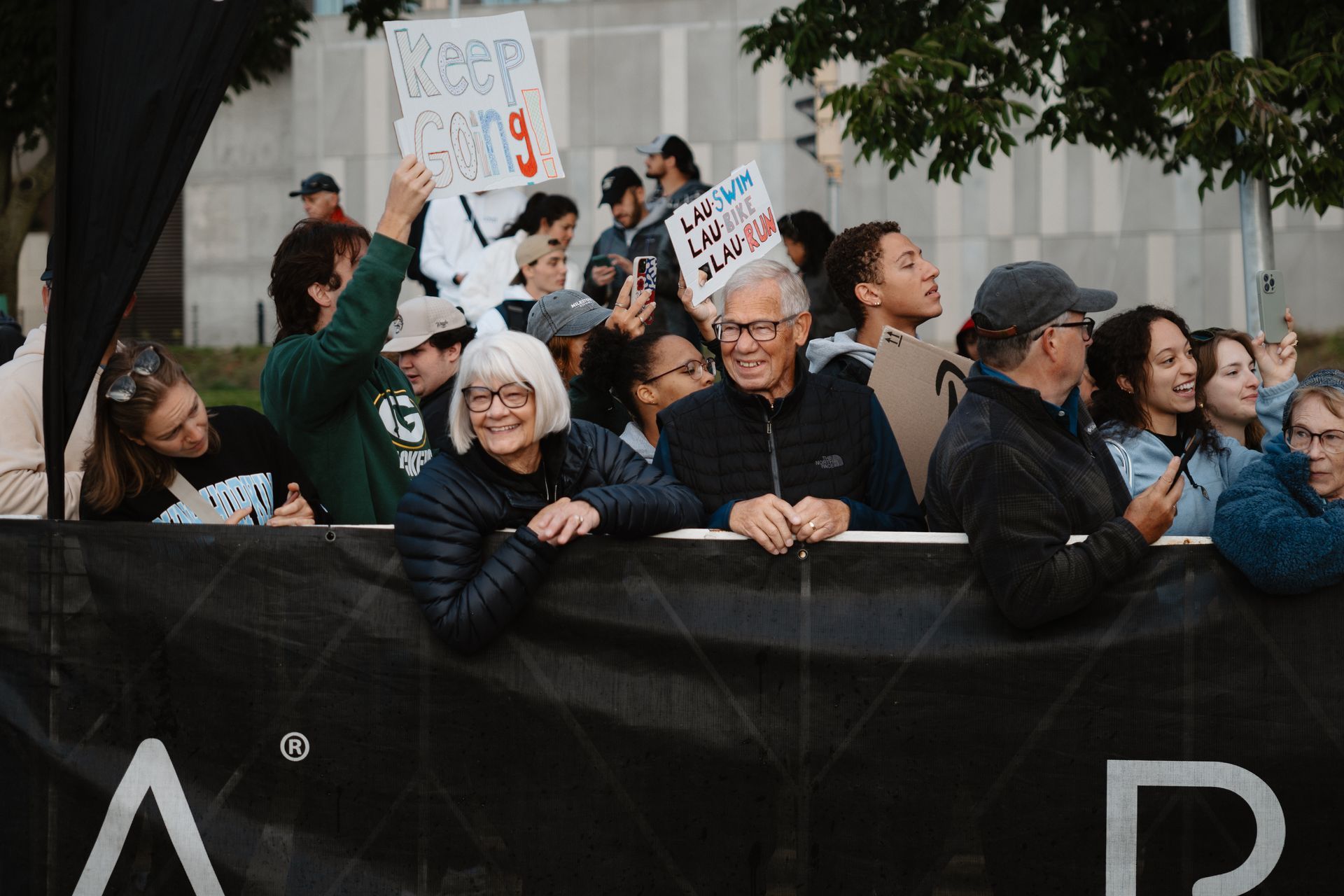 Crowd behind a barricade holding protest signs and cheering outdoors