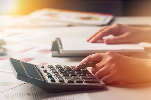 A Person Is Using a Calculator at A Desk — Blue Orchid Accounting In Woongarrah, NSW