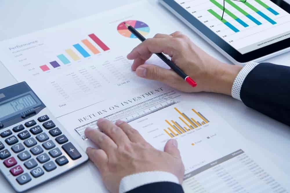 A Man Is Using a Calculator to Calculate a Return on Investment — Blue Orchid Accounting In Woongarrah, NSW