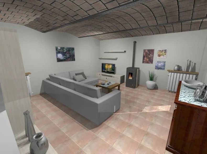 Accogliente soggiorno con pavimento piastrellato, soffitto a volta in mattoni, divano grigio, camino e vari oggetti decorativi.