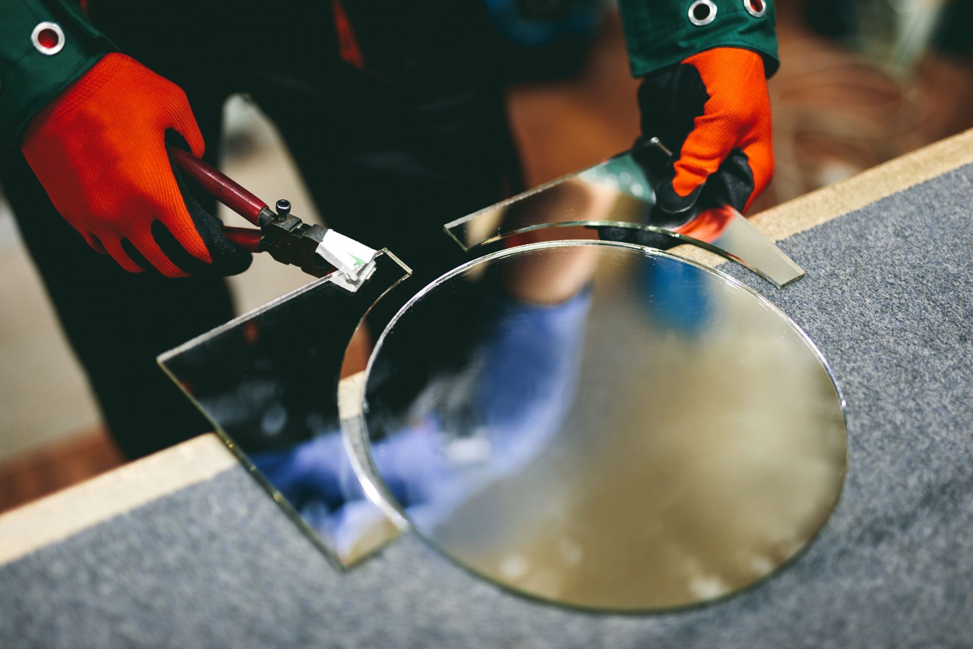 Une personne découpe un miroir avec une paire de ciseaux.