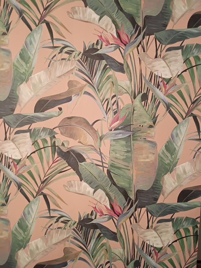 Tropical leaf wallpaper in soft pink, green, and beige tones