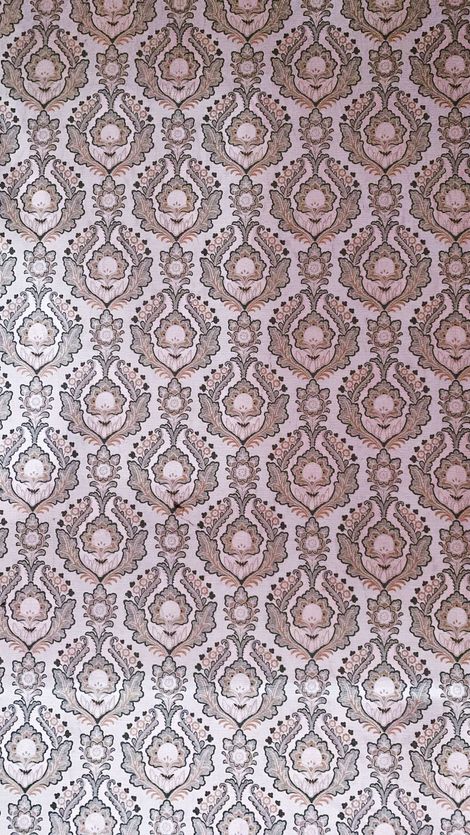 Pink and beige ornate damask wallpaper pattern with a lighter faded section at the bottom