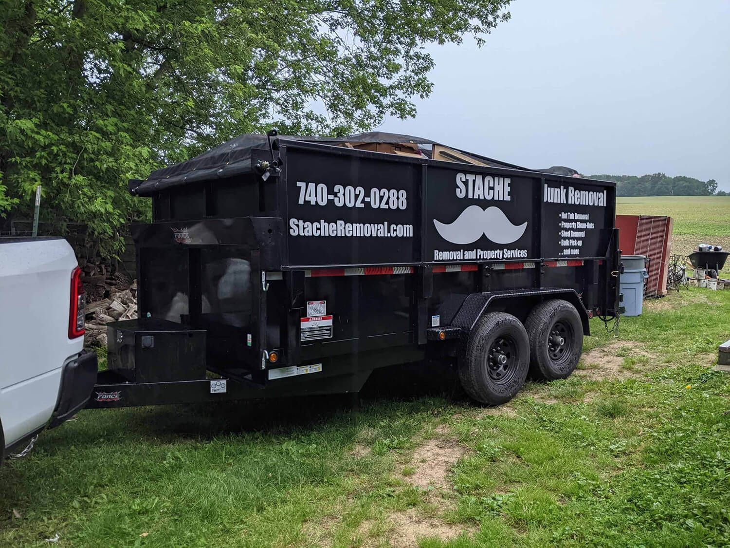 Stache Junk Removal trailer full of yard waste, yard cleanups, brush clearing