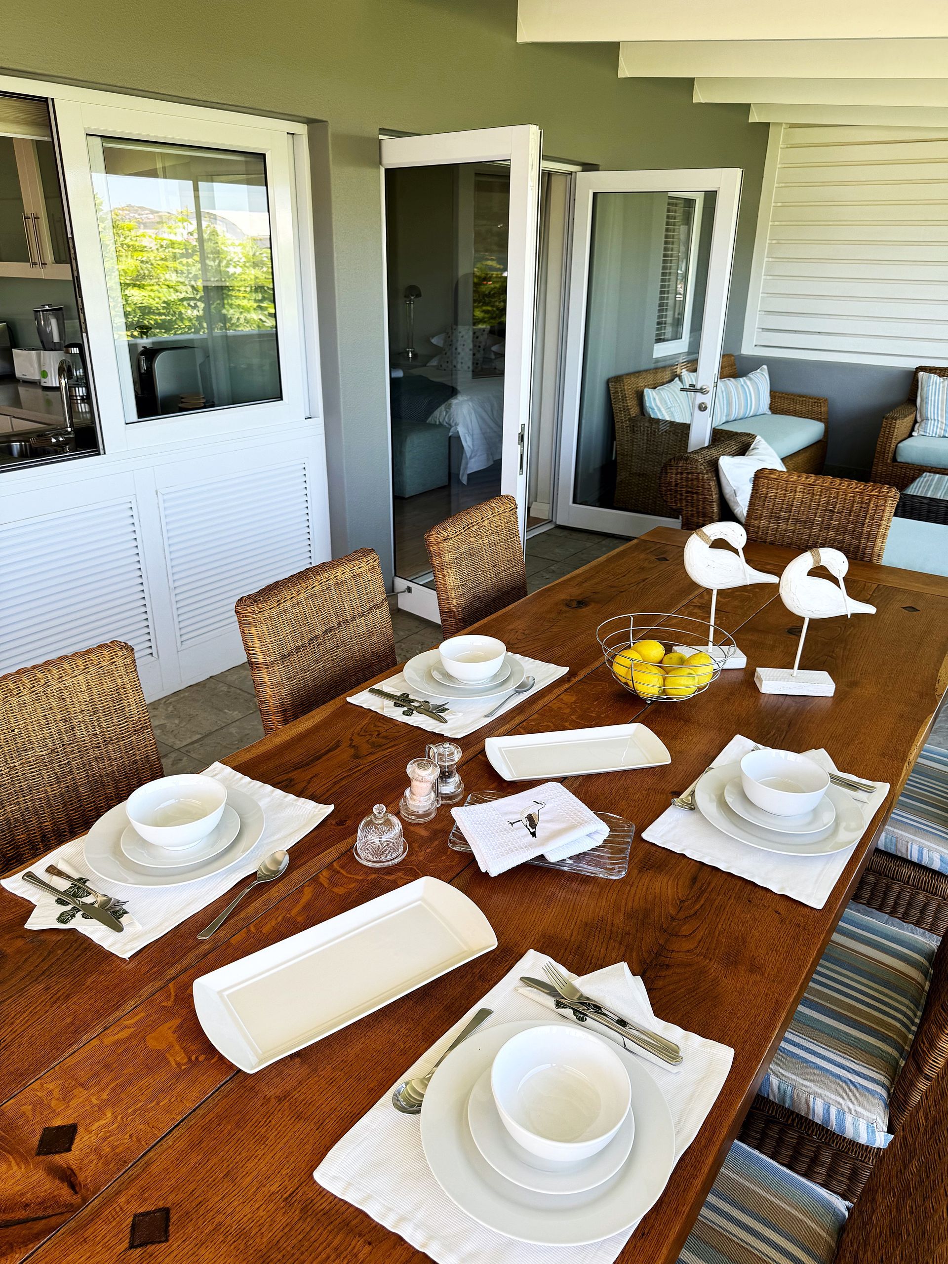 A dining room table with plates , bowls , and utensils on it.