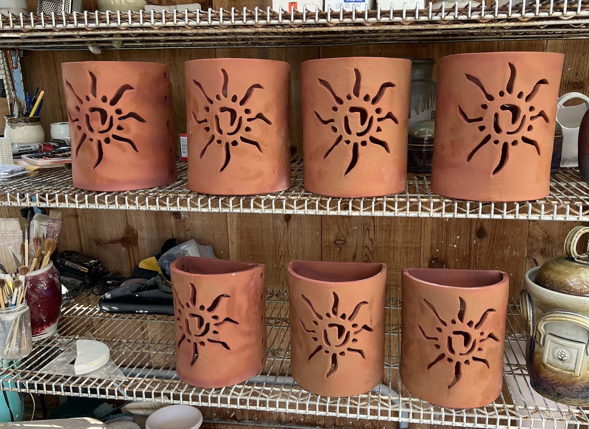 Custom terracotta light sconces with sun burst light carvings in fromt