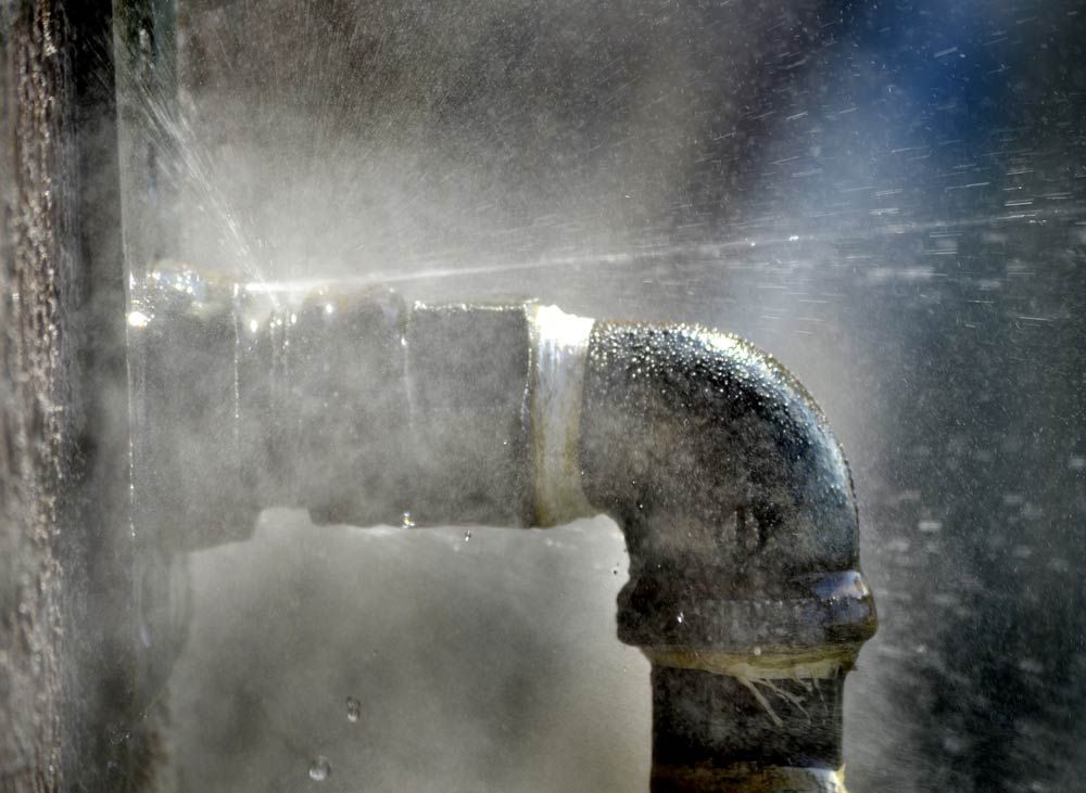 Old Rusty Pipe with Leak and Water Spraying Out — Plumbing in Wollongong
