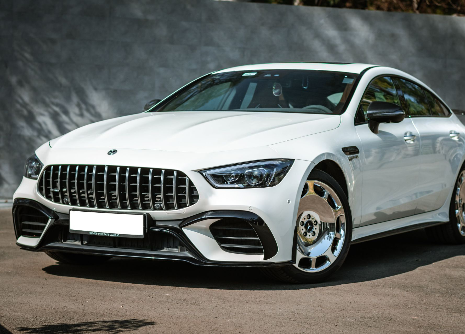 White luxury coupe parked outdoors against a dark background