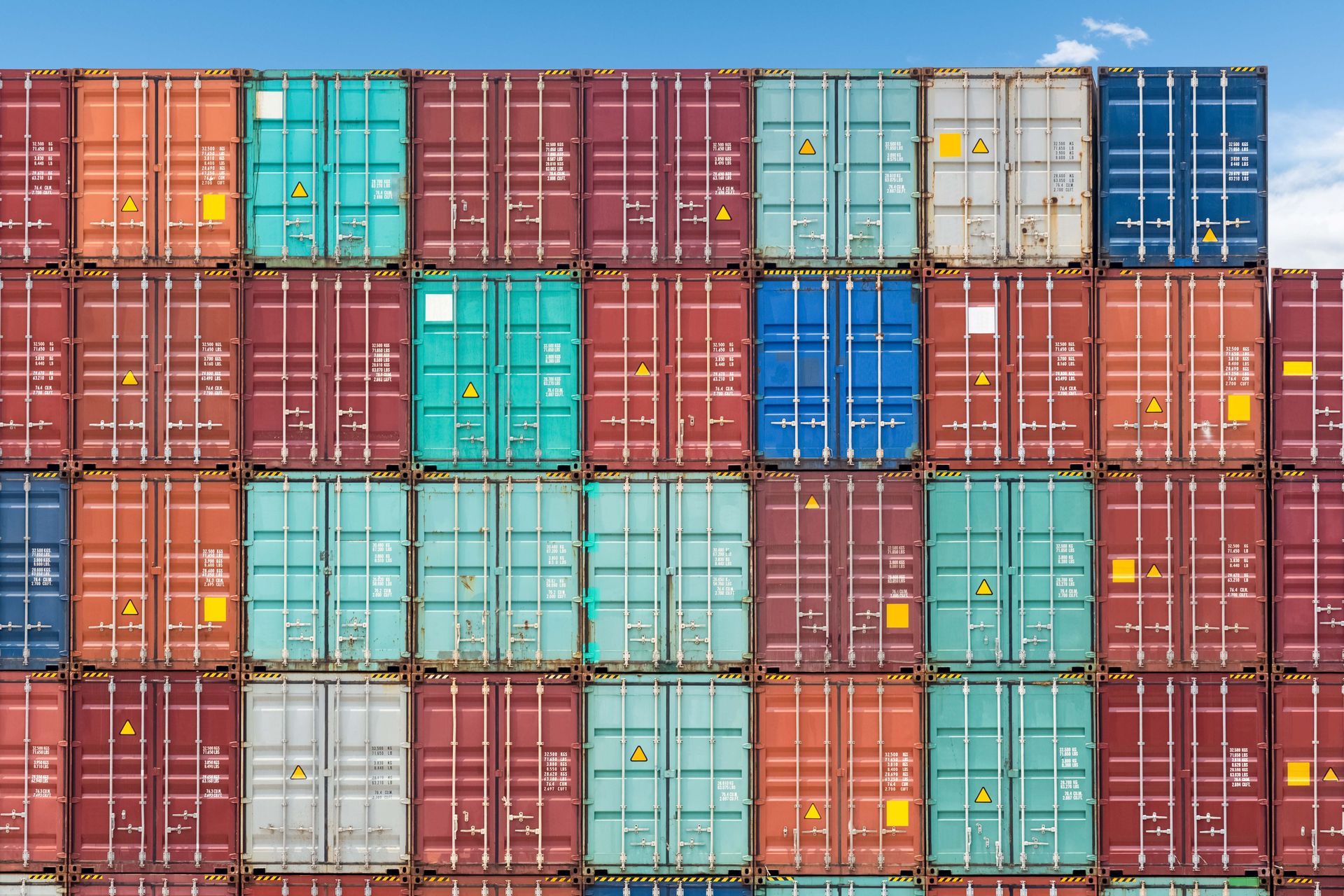 Stacked shipping containers from a commercial container supplier ready for cargo transportation.