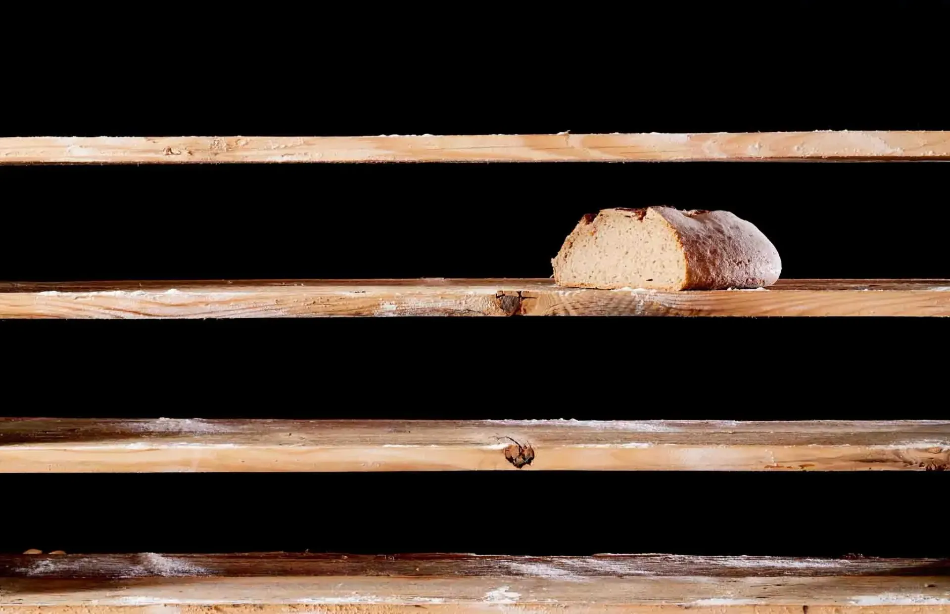 a loaf of bread is sitting on top of a wooden shelf
