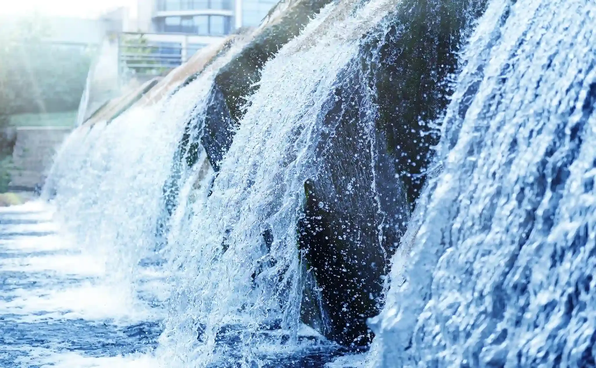 a close up of a waterfall with a building in the background .