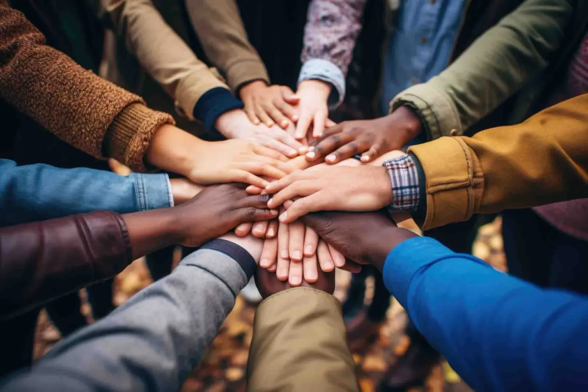 a group of people are putting their hands together in a circle
