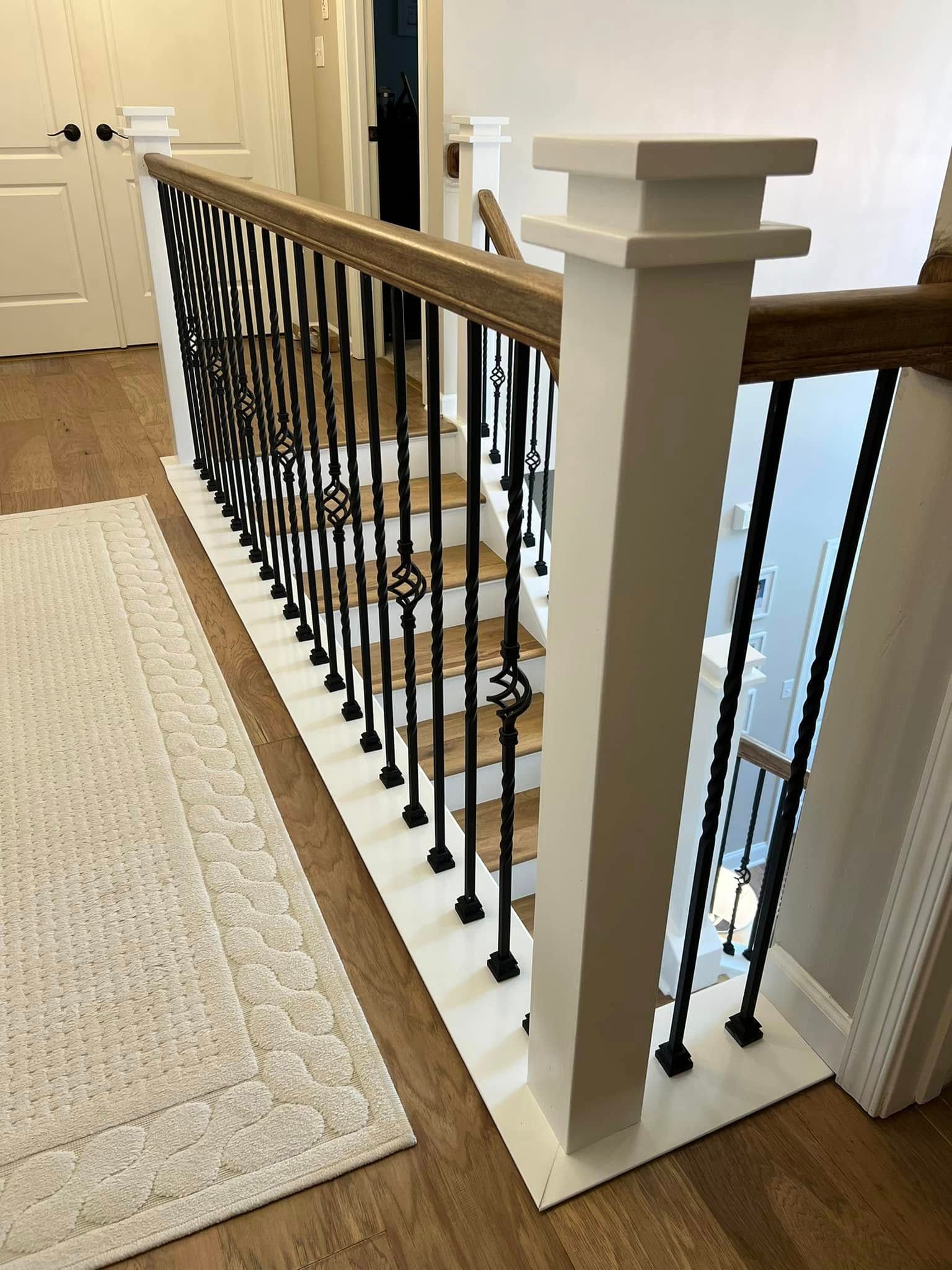 A staircase with a black railing and wooden steps in a house.