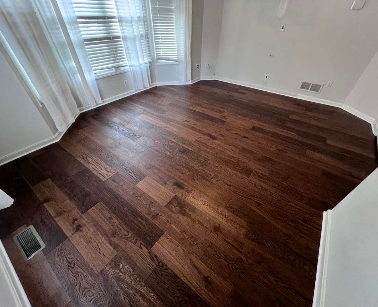 A room with hardwood floors and a window.