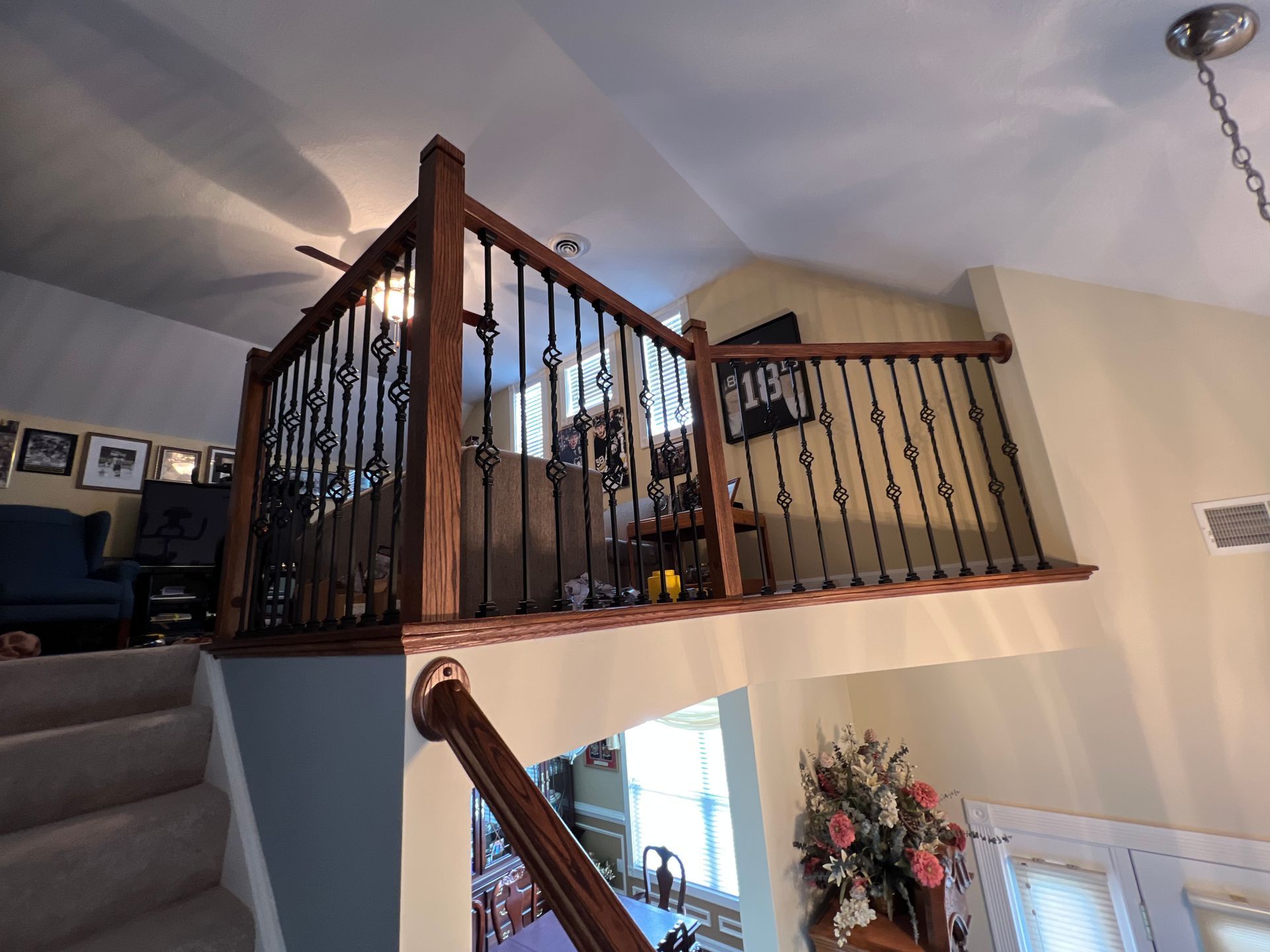 A living room with a balcony and stairs leading up to it.