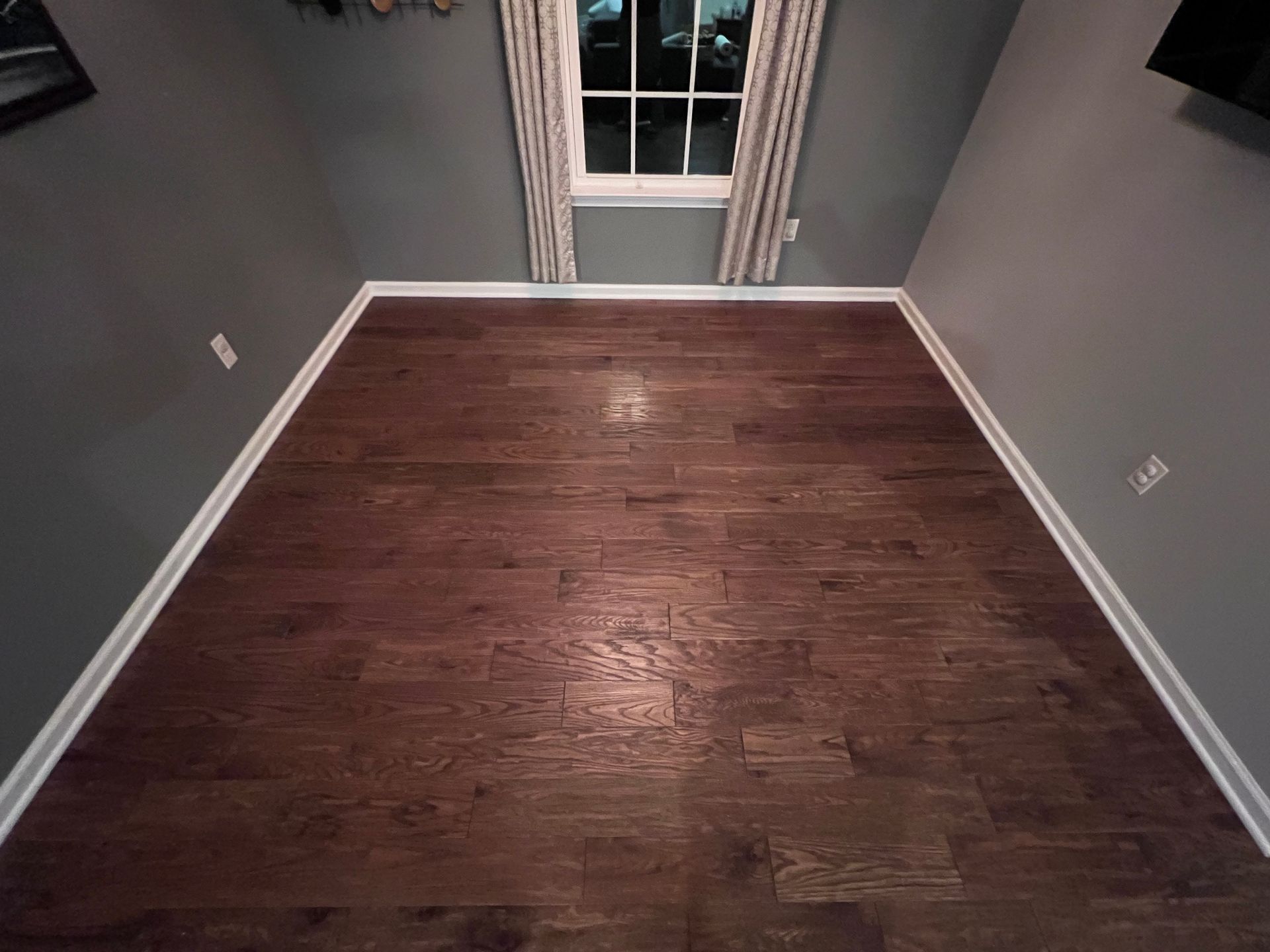 A room with hardwood floors and a window.
