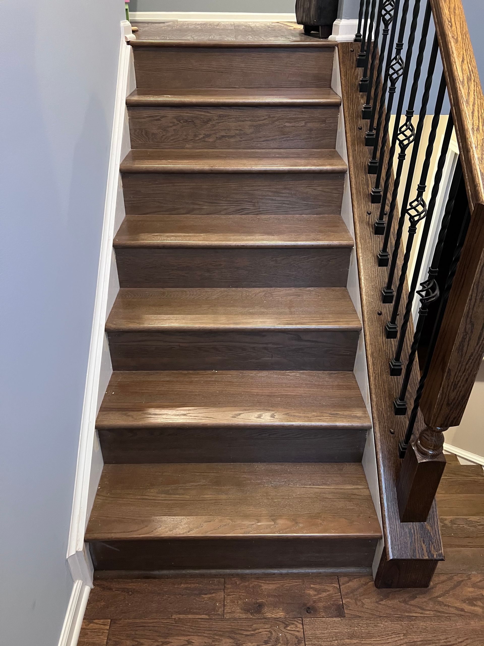 A wooden staircase with a metal railing in a house.