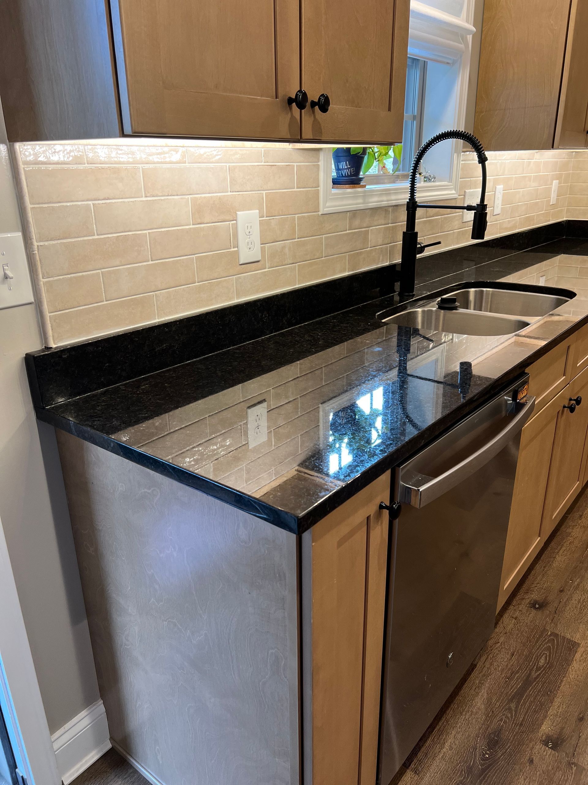 A kitchen with two sinks and a stainless steel dishwasher.