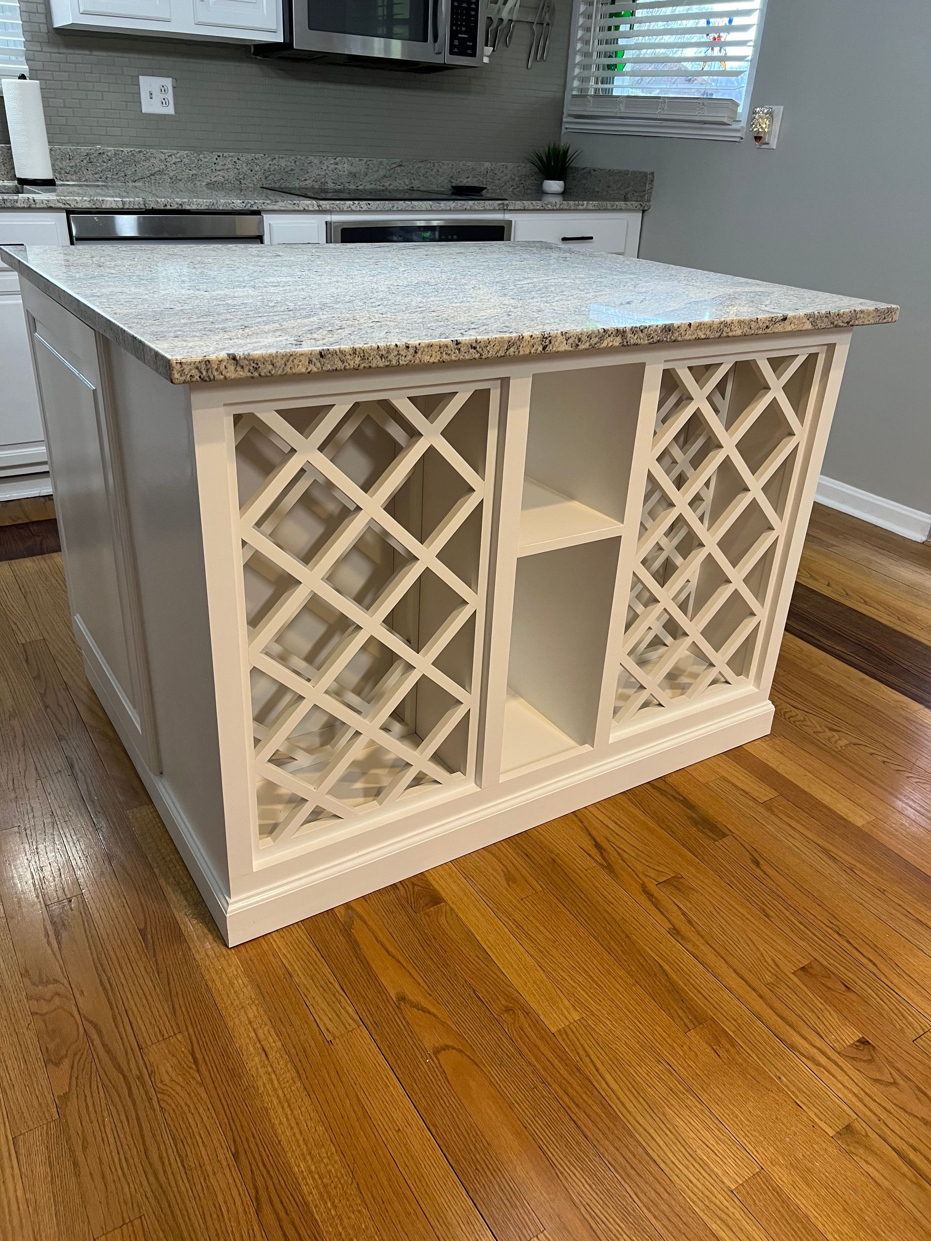 A kitchen island with a wine rack on top of it.