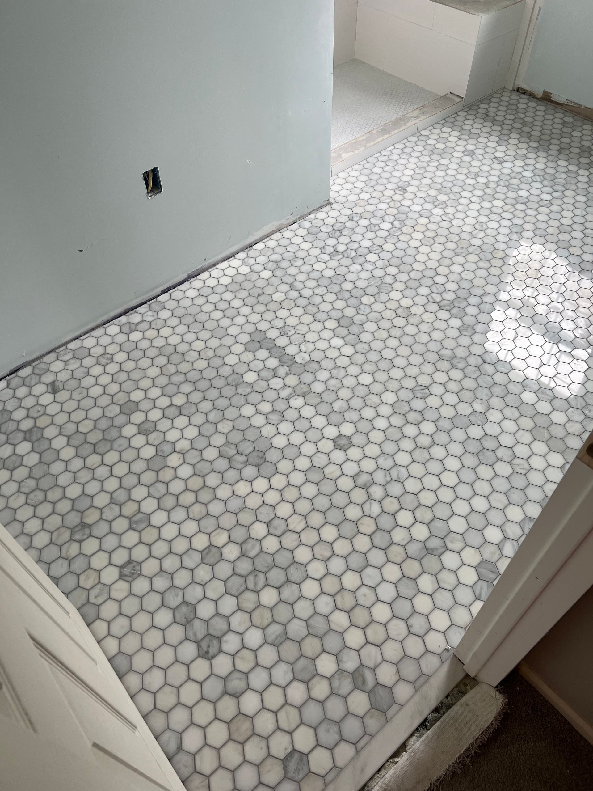 A bathroom floor with a hexagonal tile pattern