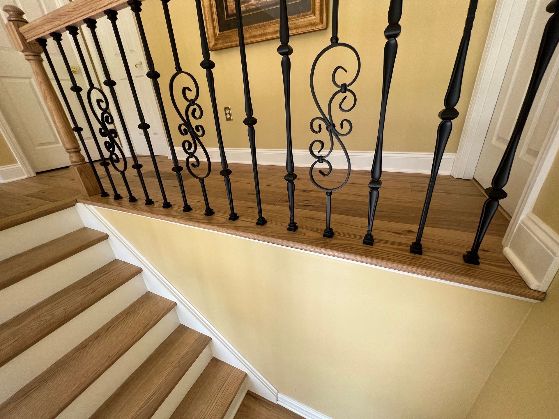A staircase with a wrought iron railing and wooden steps
