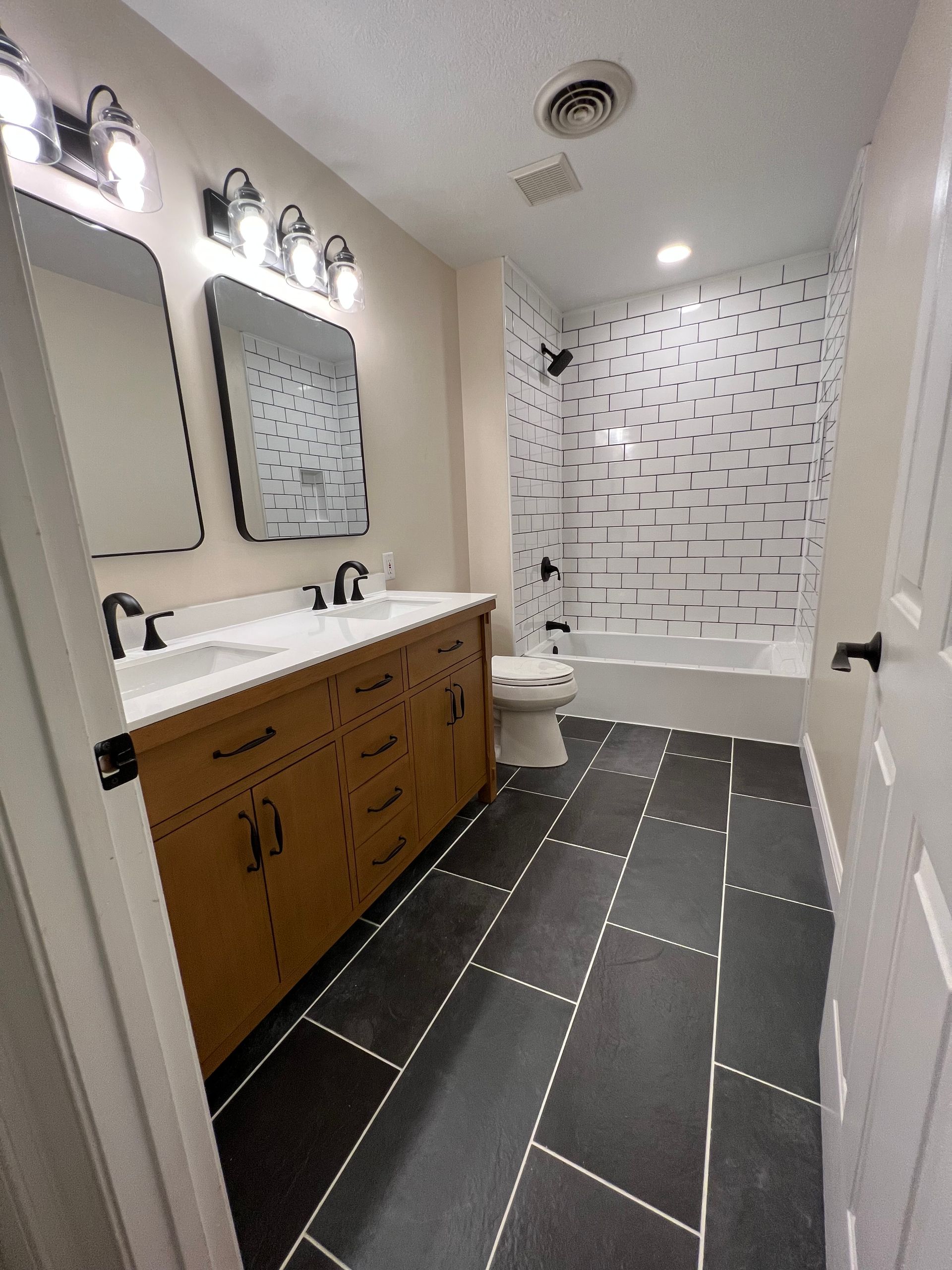 A bathroom with two sinks , a toilet , and a bathtub.