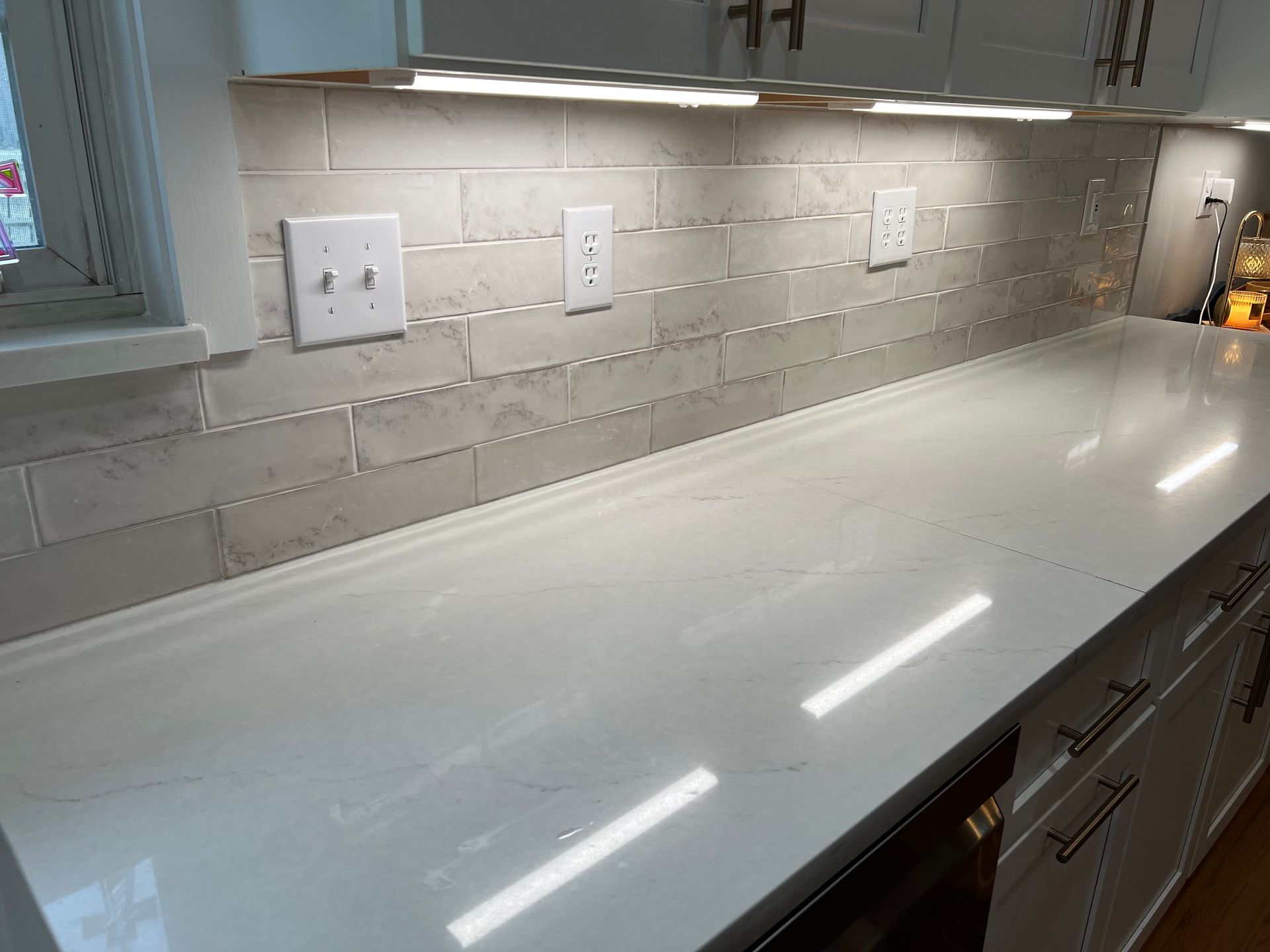 A kitchen counter with white cabinets and a white counter top.