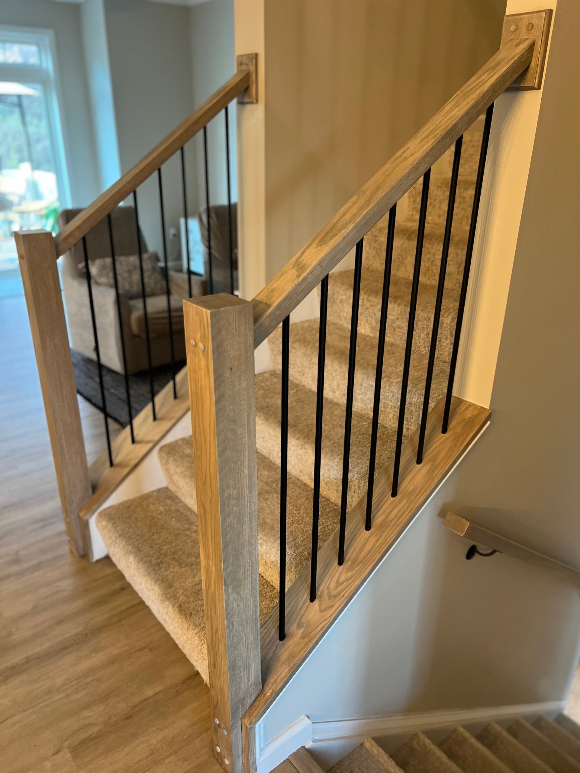 A wooden staircase with a metal railing in a house.