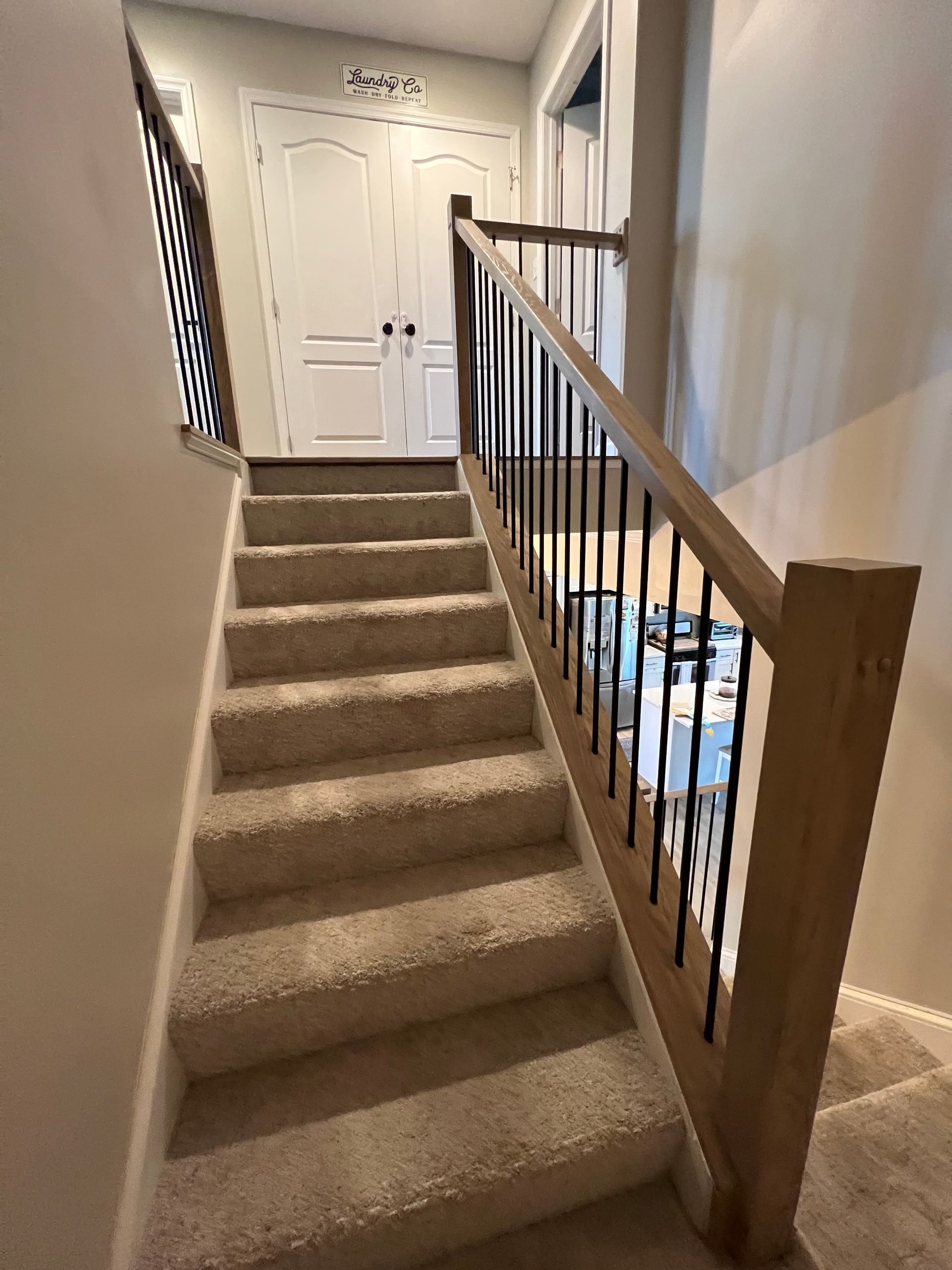 A staircase with carpeted steps and a wooden railing in a house.