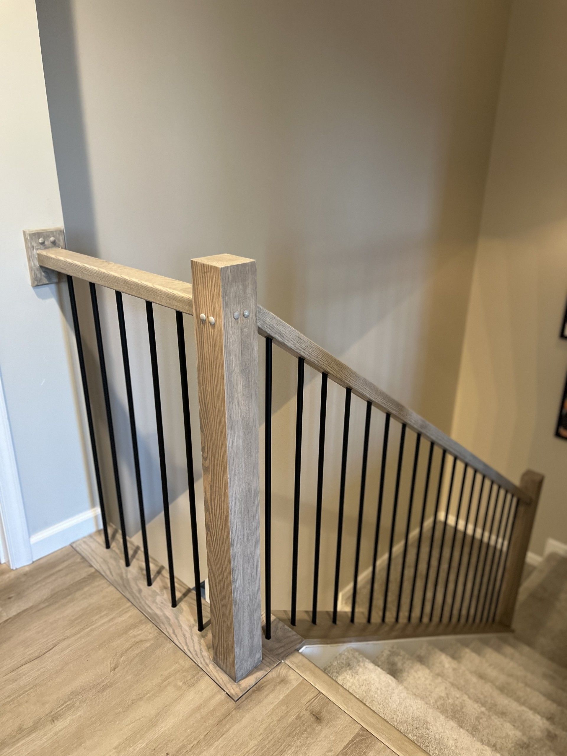 A wooden staircase with a metal railing in a house.