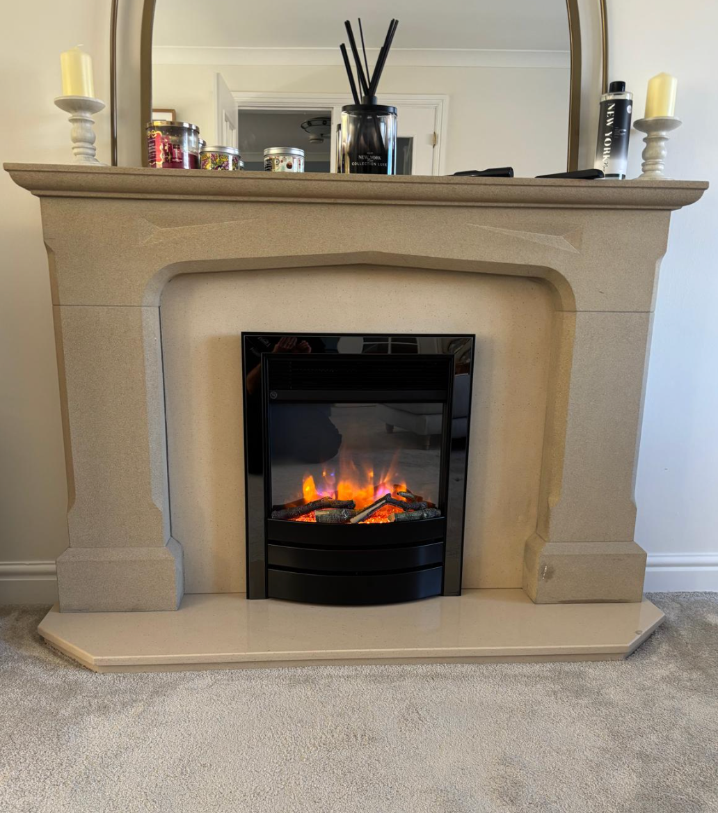 Beige fireplace mantel with electric fire glowing in a carpeted living room
