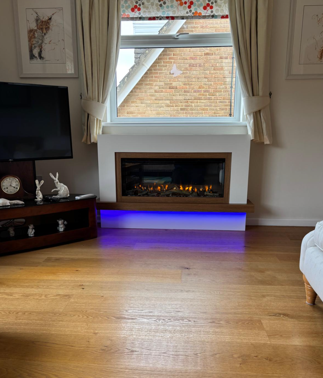 Living room with white fireplace, blue underglow, TV stand, and large window with curtains