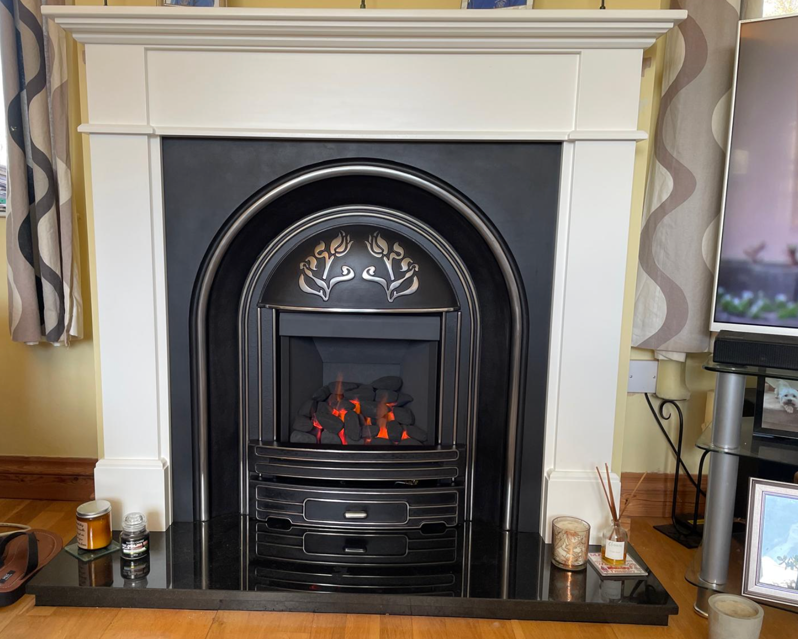 White mantel fireplace with black surround and glowing electric fire in a living room