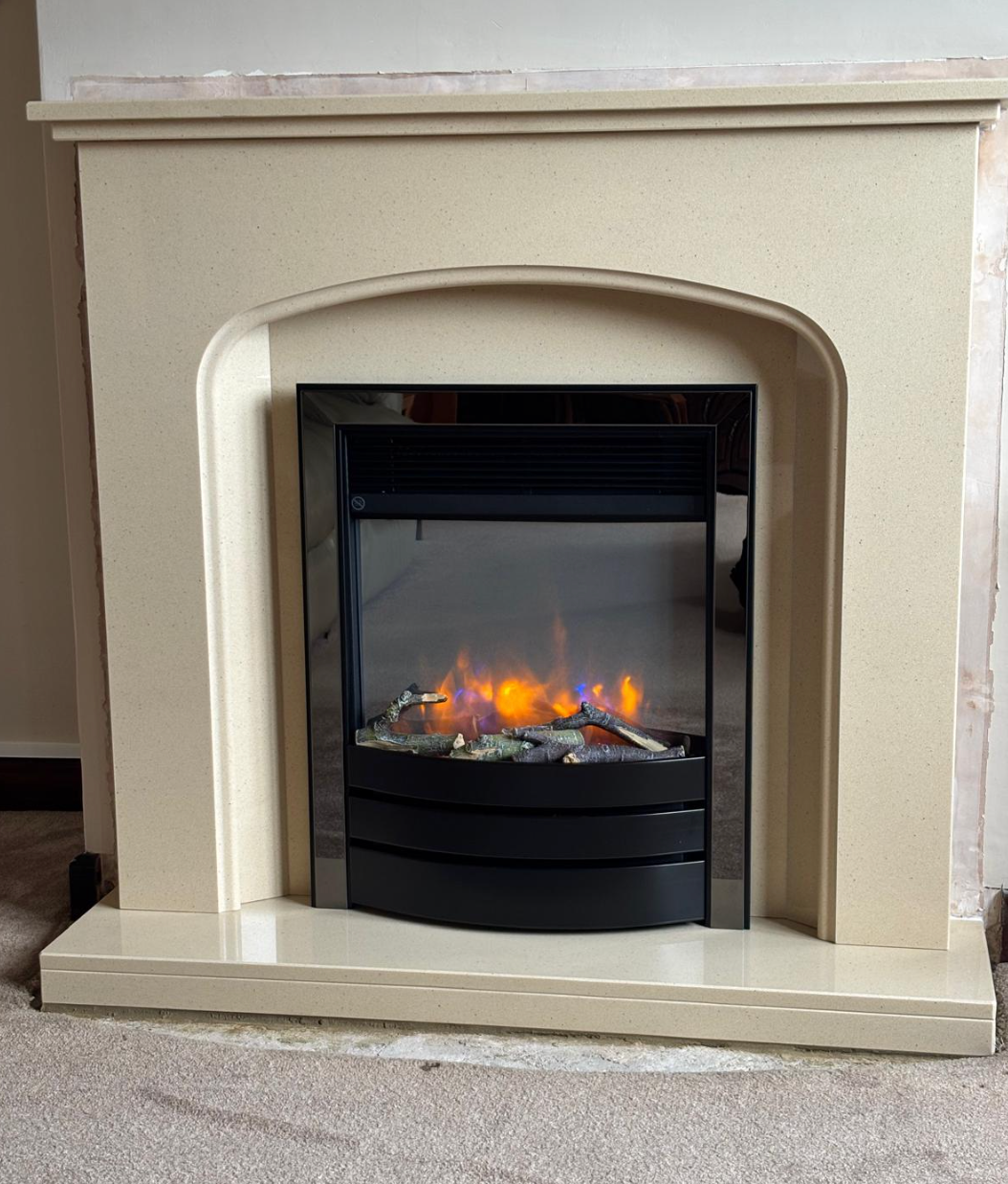 Cream fireplace with a black electric fire insert glowing orange flames