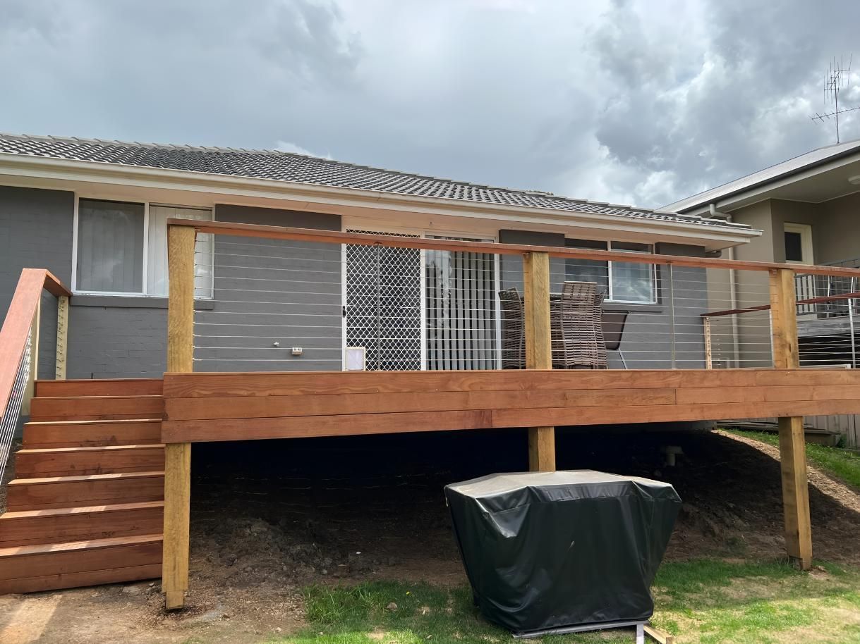 Wooden Deck Attached to a Gray House With Stairs — LD Carpentry in Moss Vale, NSW