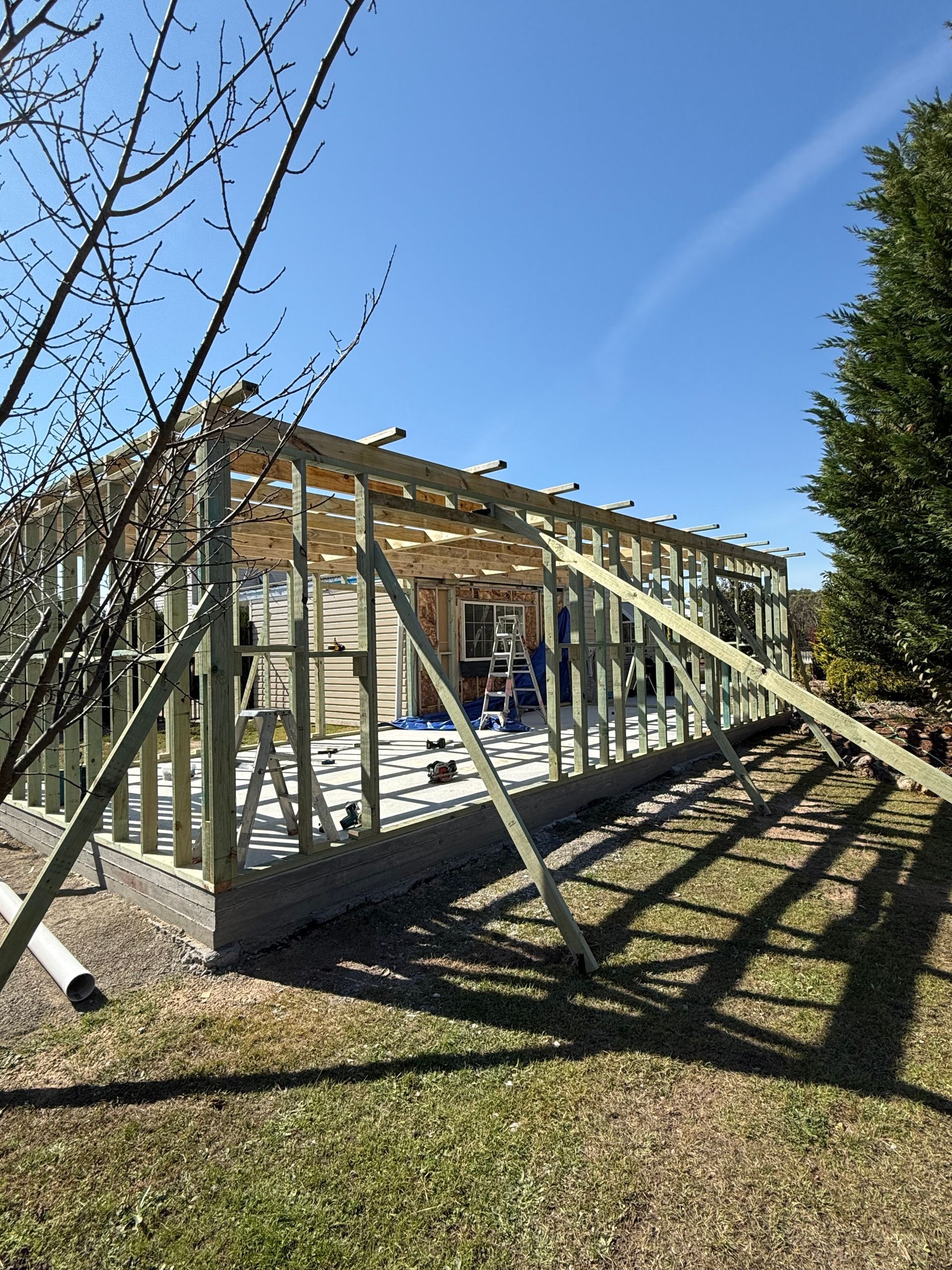 Wooden structure under construction in a grassy yard on a sunny day — LD Carpentry in Goulburn, NSW