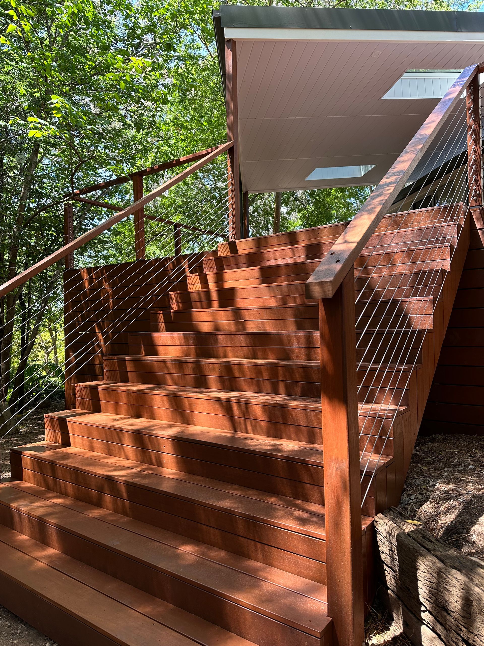 Wooden stairs leading up to a cabin. Brown railing, stairs, and decking — LD Carpentry in Goulburn, NSW