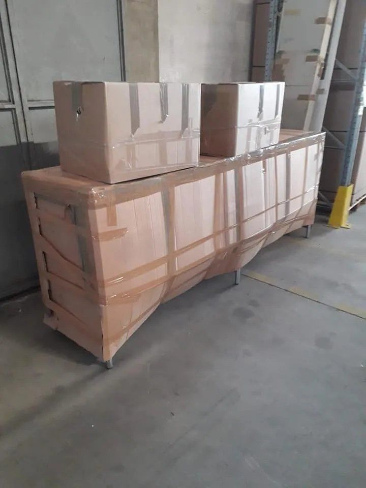 Scatole di cartone avvolte e impilate su un pallet in un magazzino o in un'area di carico.